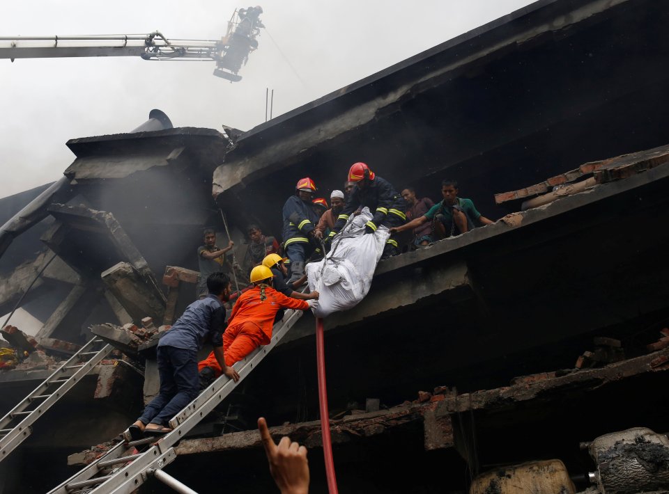  Firefighters remove a dead body at a garment packaging factory