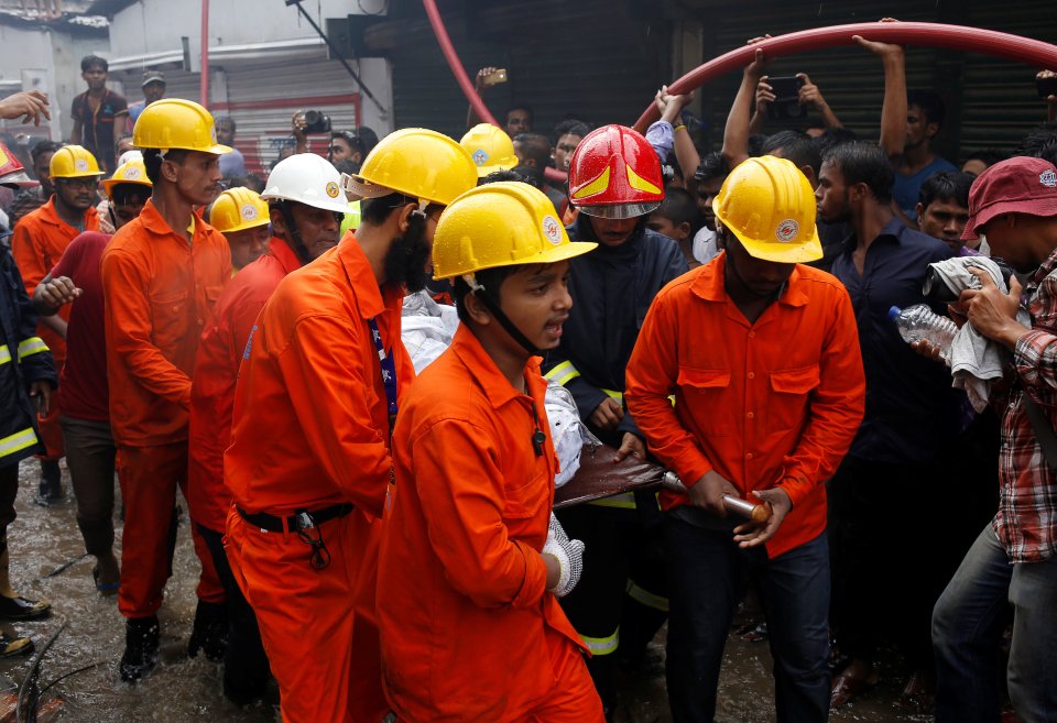  Rescue team members remove a dead body at a garment packaging factory after a fire broke out outside of Dhaka, Bangladesh