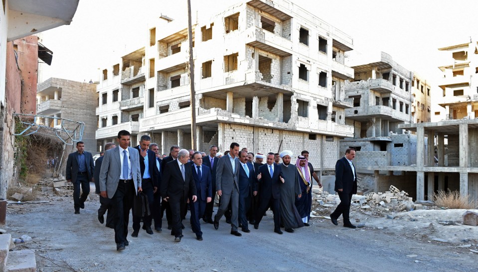  President Bashar al-Assad walks through street in Daraya, a suburb recently liberated by government forces