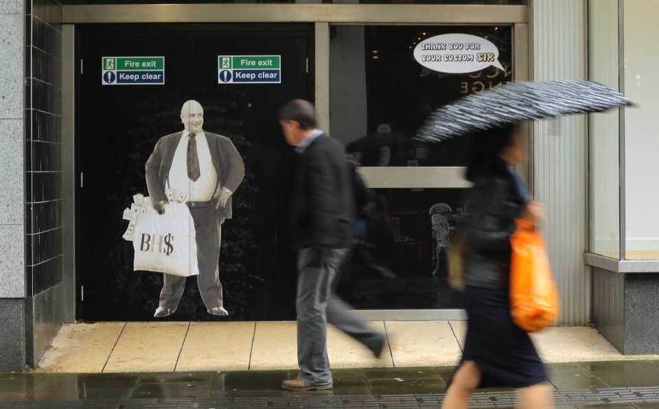  Shoppers walk past a poster of Sir Philip Green on the door of the now closed down BHS store in Oxford Street, Swansea