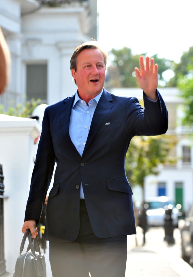  Greetings . . . Cameron waves outside house while in Westminster a group of Welsh MPs are trying to get their office back