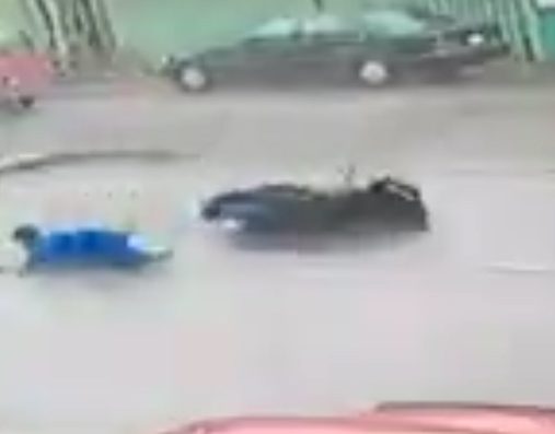  The rider is sent skidding across the road as rain hammers down on the road