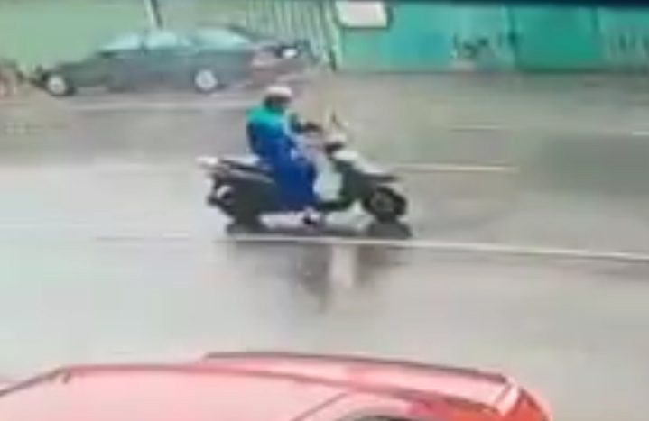  Incoming! A scooter rider drives down a road in Super Typhoon Meranti unaware a huge piece of debris is flying towards