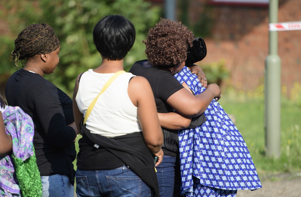  Grieving friends and relatives console each other after a double shooting in East Finchley this morning