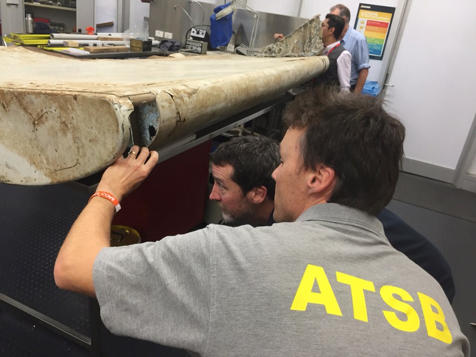  Australian Transport Safety Bureau staff examine the wing flap found off the coast of Tanzania