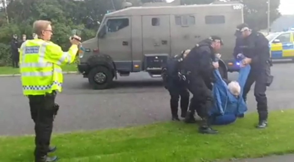  The elderly man is dragged away by cops after holding up traffic and sparking anger from drivers