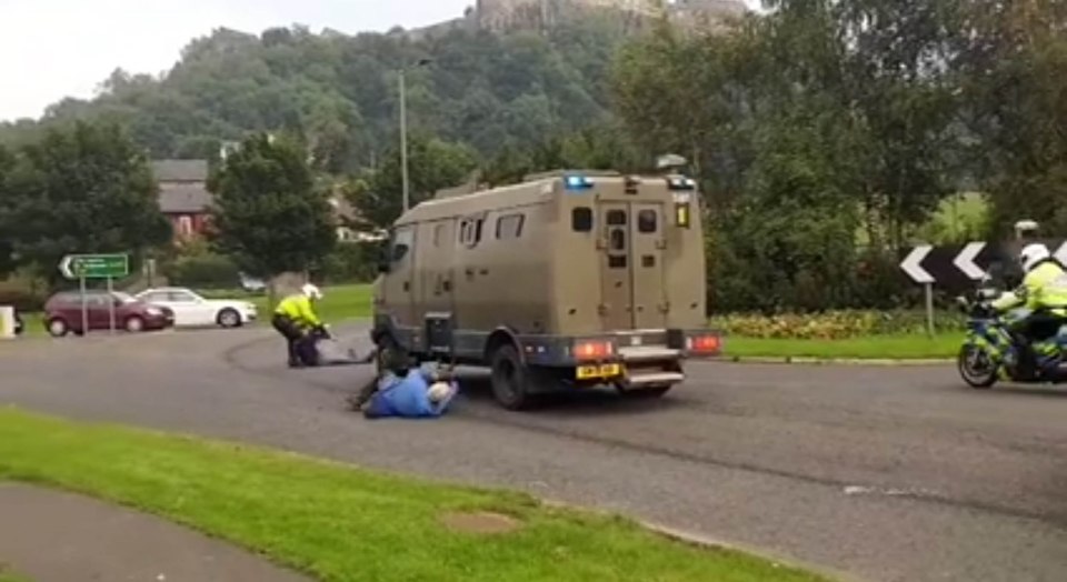  The 77-year-old, believed to be a former teacher, lies down at the wheel of the van stopping it from moving as police move in