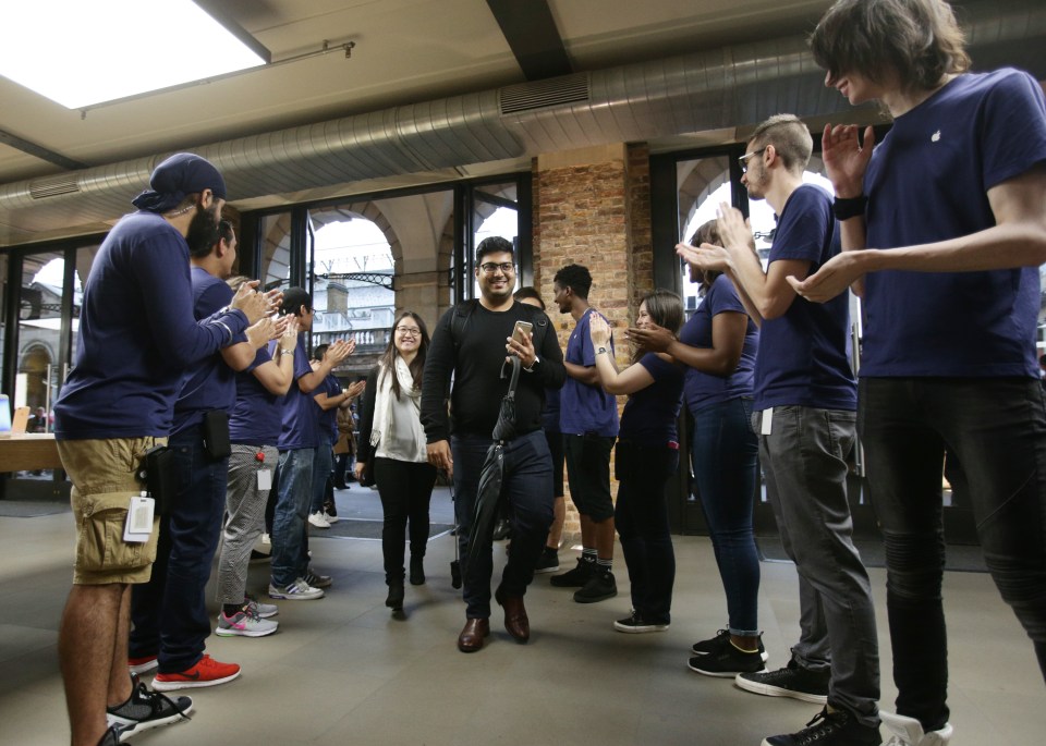  Clapping workers greeted customers as they streamed into the Apple store in London to pick up their pre-ordered phones