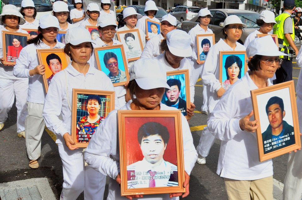  Members of the spiritual movement Falungong protest by holding portraits of alleged victims during a demonstration in Taipei