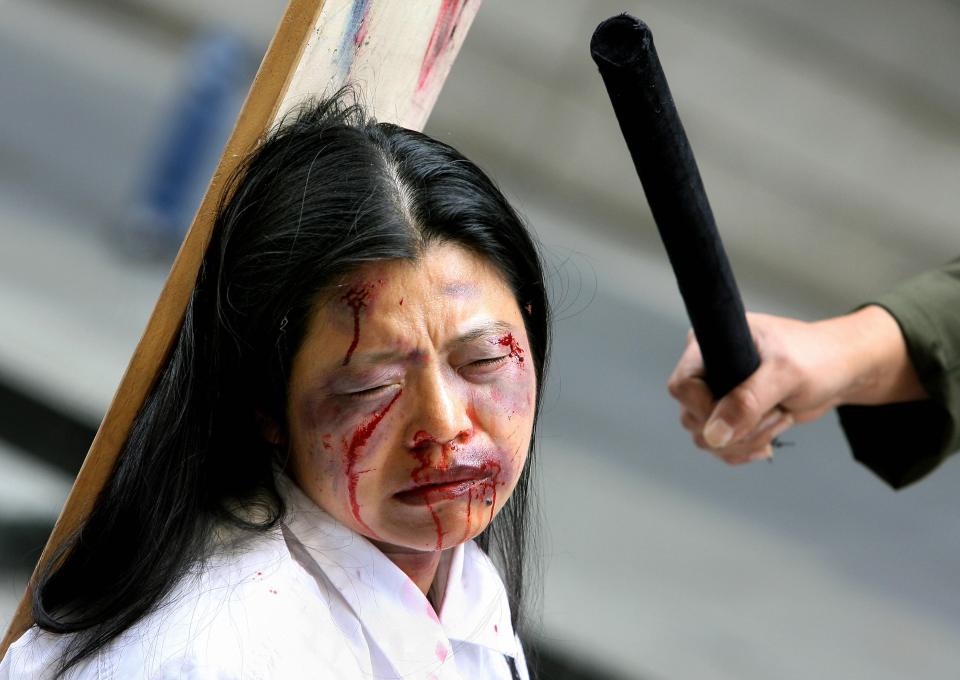  Falungong practitioners act out a torture scene as they protest against 'Chinese government's torture and abuse' in Sydney