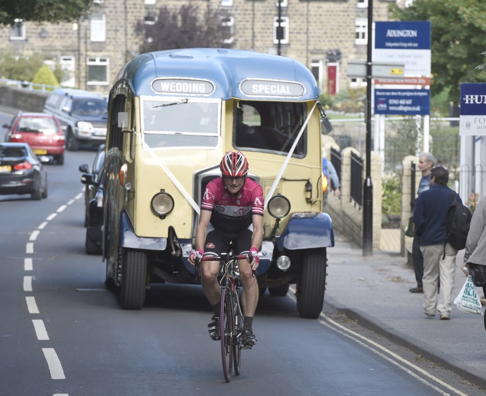  Lizzie Armitstead's vintage wedding coach slowly follows a lone cyclist on her way to the church