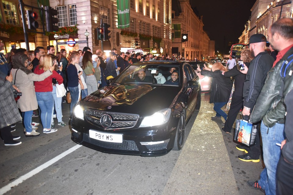  The occupants of a sleek black Mercedes were clearly enjoying the attention they received