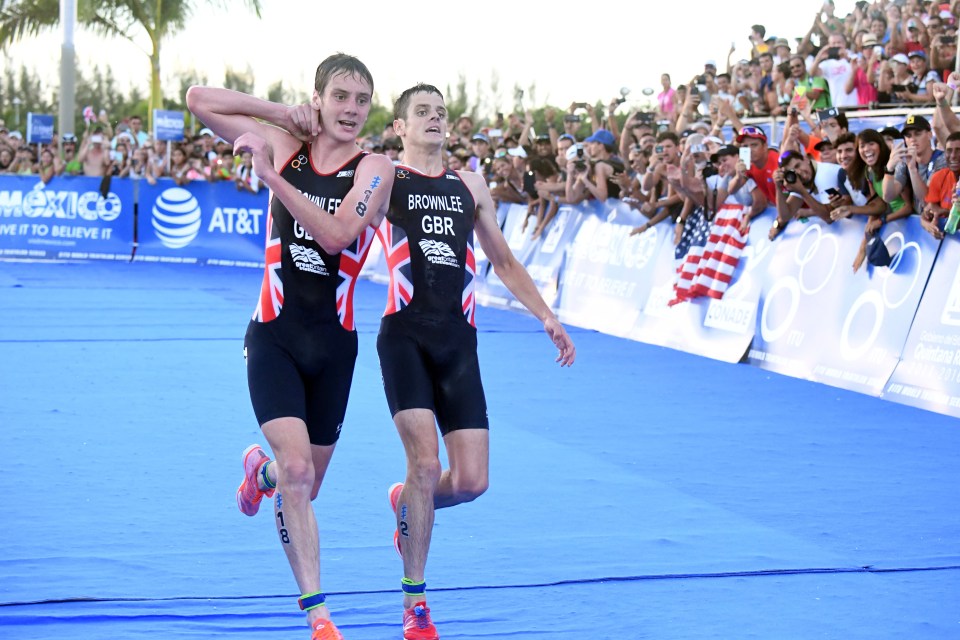  Britain's Alistair Brownlee, left, helps his brother Jonny over the finish line at the World Triathlon Series