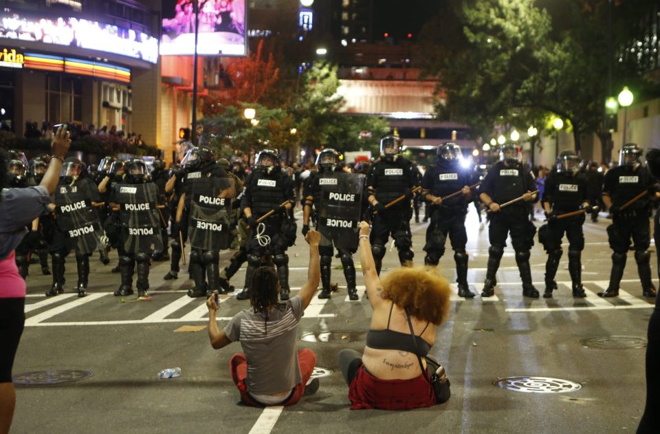  Crackdown . . . protesters sit in front of baton-wielding cops