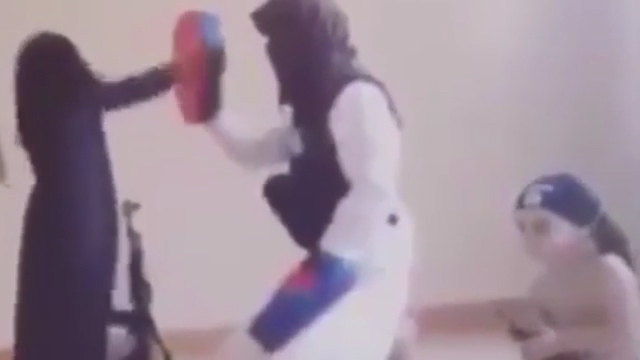 The young girl is taught to punch in the suspected ISIS video