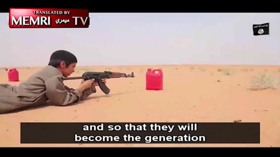  This boy is being taught how to wield a deadly Kalashnikov rifle