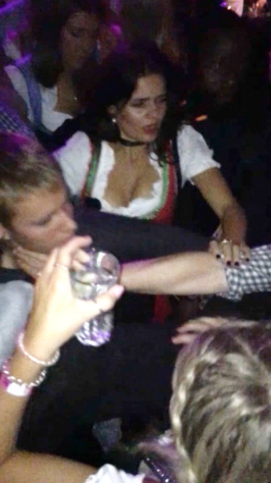  A woman working in the club dressed in traditional Germ garb can be seeing trying to remove the man's arm