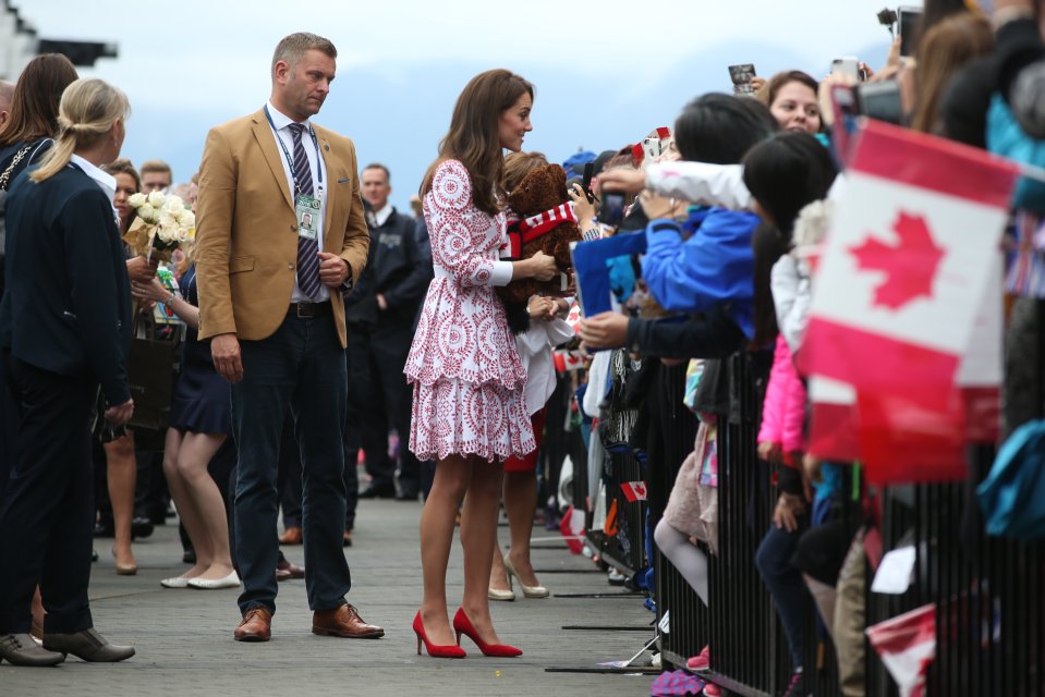  Kate wore a pair of bright red stilettos which complimented her choice of a red and white dress as she chats with the crowd