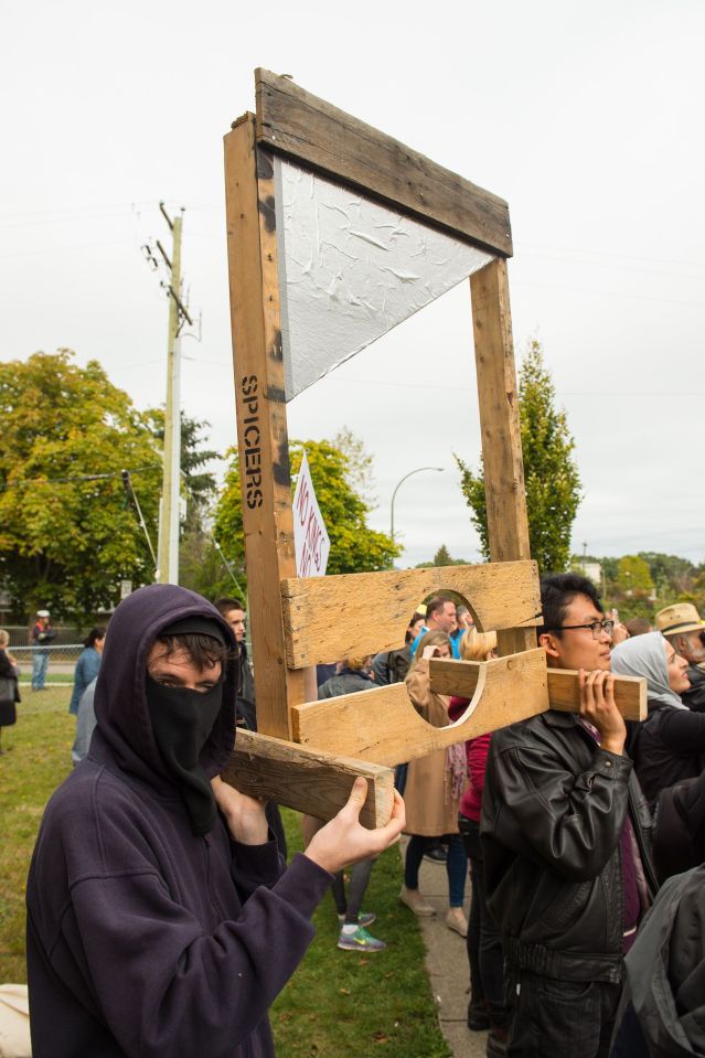  Some of those in the crowd greeting them on their excursion were protesters holding a large wooden guillotine