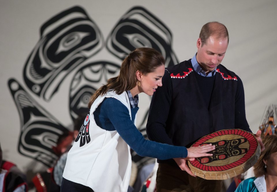 Wearing First Nations vests they were given, Britain's Prince William, the Duke of Cambridge, and Kate, the Duchess of Cambridge, hold a traditional drum they were presented during a welcoming ceremony at the Heiltsuk First Nation in the remote community of Bella Bella,