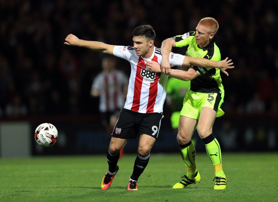 Brentford's Scott Hogan and Reading's Paul McShane battle for the ball