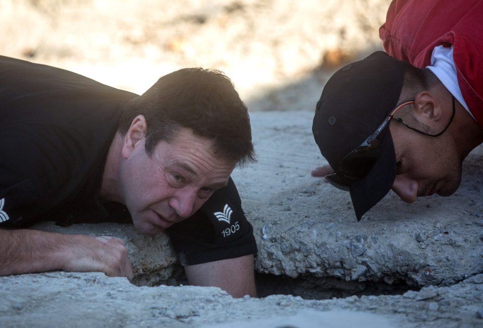  A police officer look inside a hole cut into a septic tank as the search for Ben Needham continues