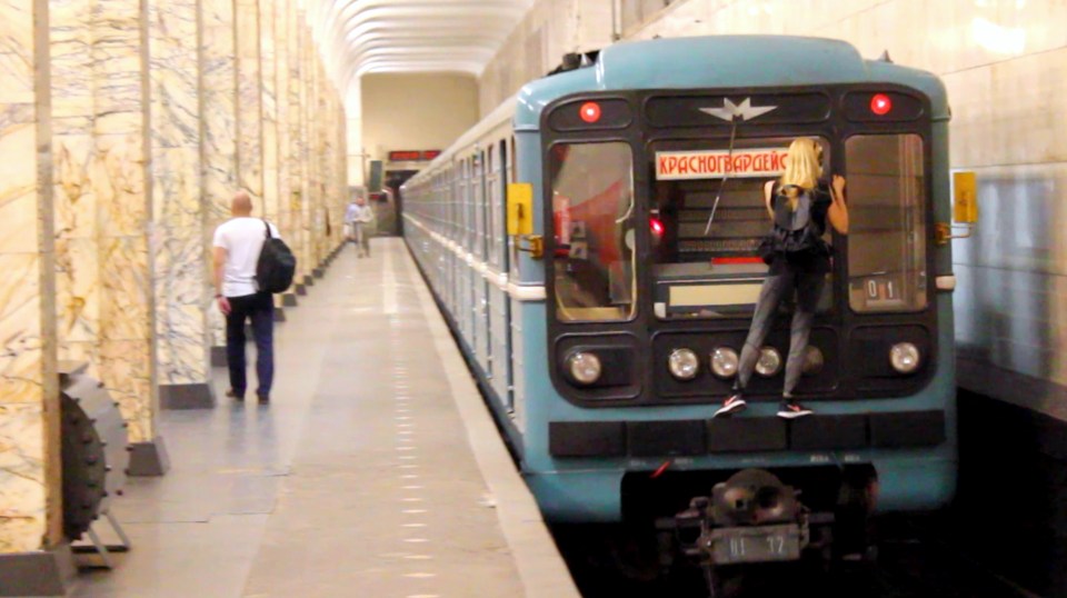  She hangs onto the back of the train as it leaves the station