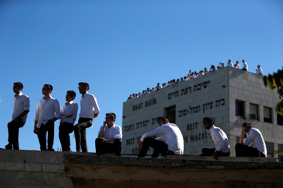  People climbed and sat on the tops of walls or watched from the roofs of buildings as the ceremony began