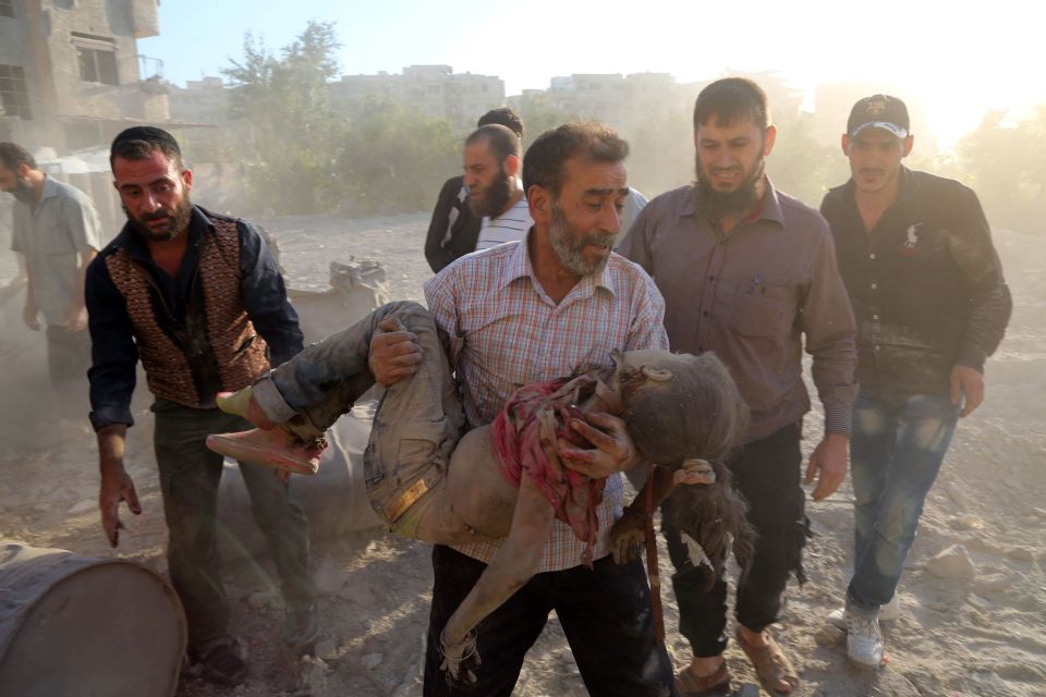  A Syrian man carries the body of a girl following reported airstrike on Kafr Batna