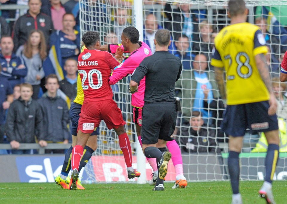  Swindon's keeper Lawrence Vigouroux swings a punch at Oxford's Alex MacDonald