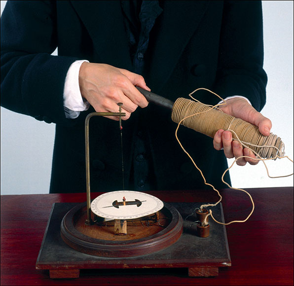  A permanent magnet being moved into and out of a coil of wire. The meter on the bench measures the electric current produced