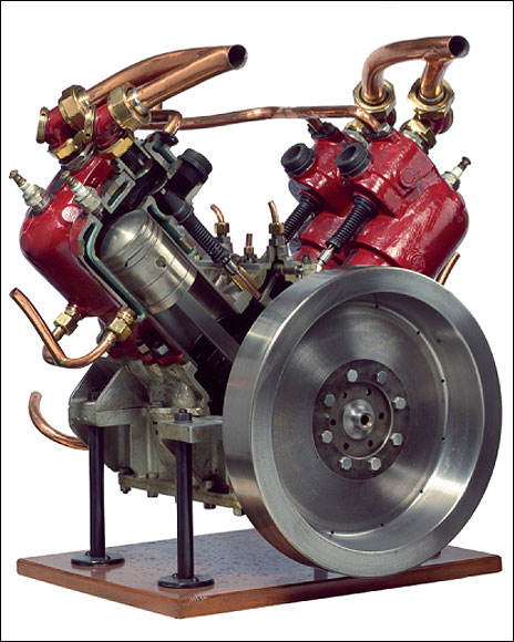  Look inside. The piston is visible inside this cutaway four-cylinder, four-stroke Ader engine from 1903. At the top of each cylinder, you can see a spark plug