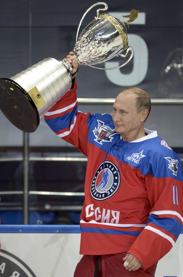  A victorious Putin holds the winner's trophy aloft