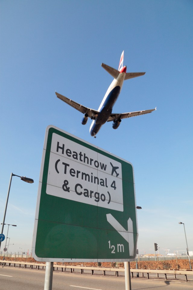 A BA (British Airways) airplane passes an A30 road sign beside Heathrow Airport, London, UK (close to Hatton Cross station).