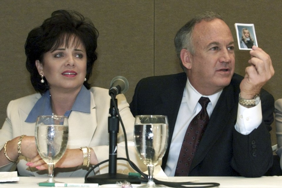  Patsy Ramsey looks down as her husband John produces a picture of their daughter during a press conference where they released the results of an independent lie detector test