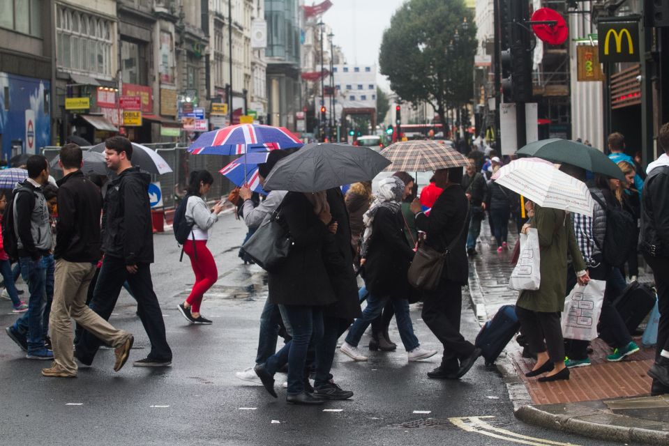  Shoppers shelter from the rain on Tottenham Court Road in London today