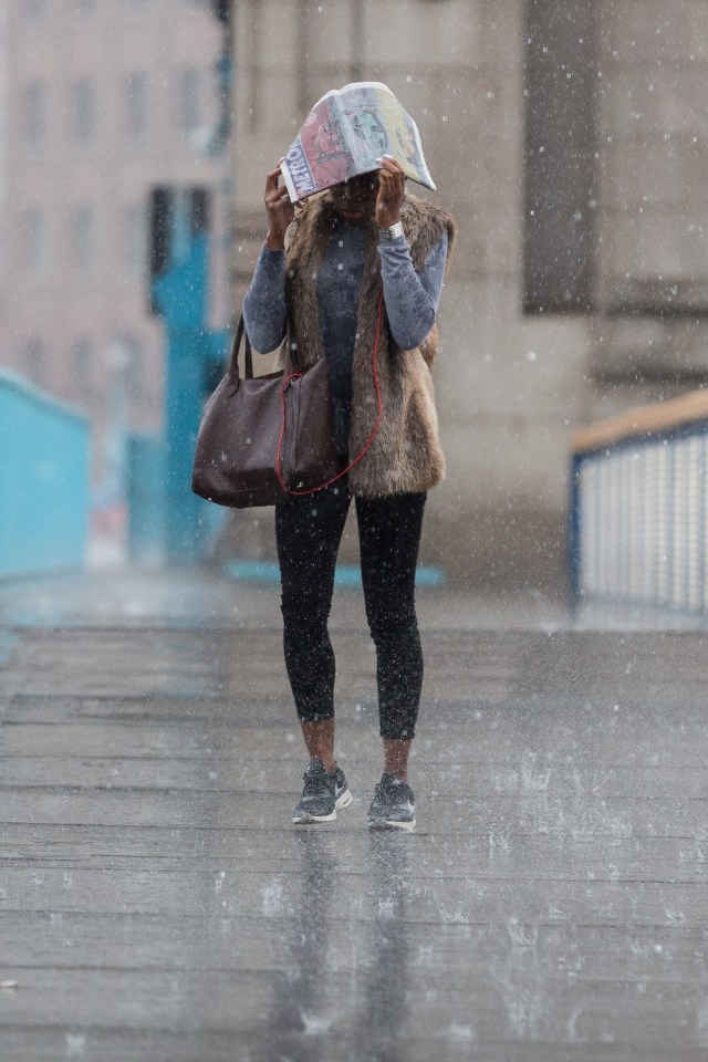  A downpour catches a pedestrian unprepared in London Bridge today