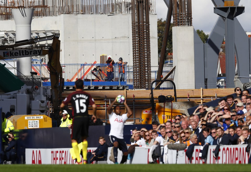 Builders watch on from the construction site behind White Hart Lane 