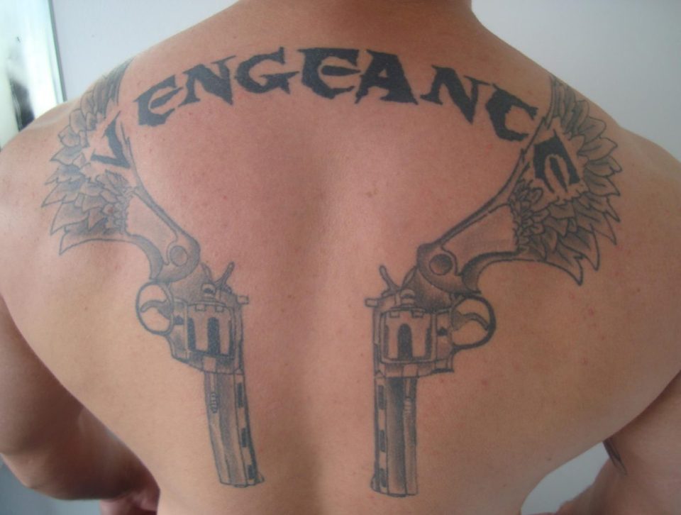  Threatening tatt . . . Ali has a tattoo with 'vengeance' and two pistols on his back