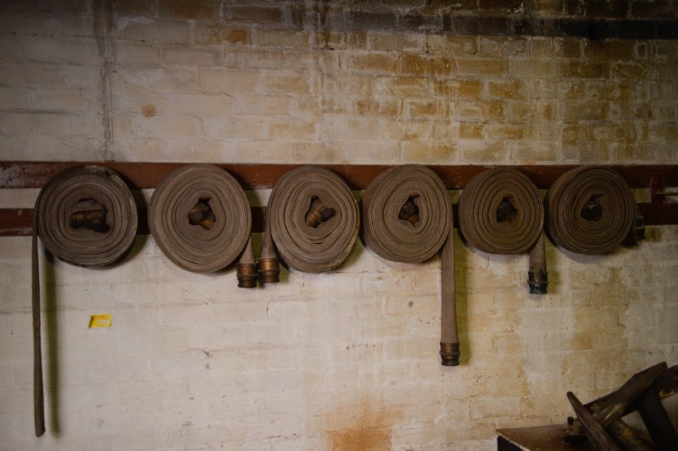  Fire houses are neatly coiled against the white-washed wall in the fascinating space that gives an glimpse into a forgotten age