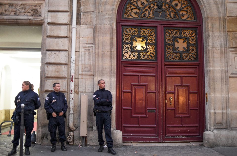  French cops stand guard outside the Paris apartment where the raid occurred