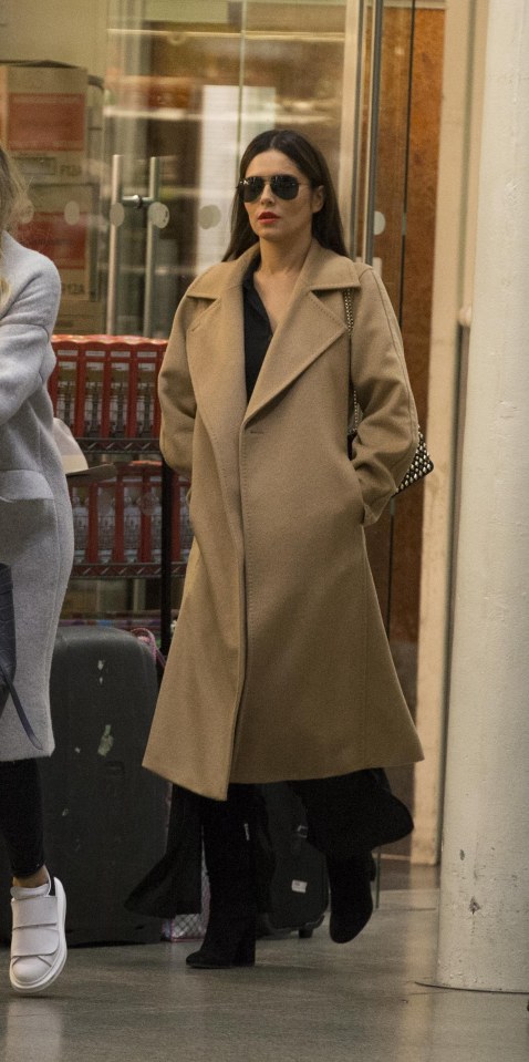  Cheryl covered her rumoured baby bump in an oversized coat as she arrived back from Paris