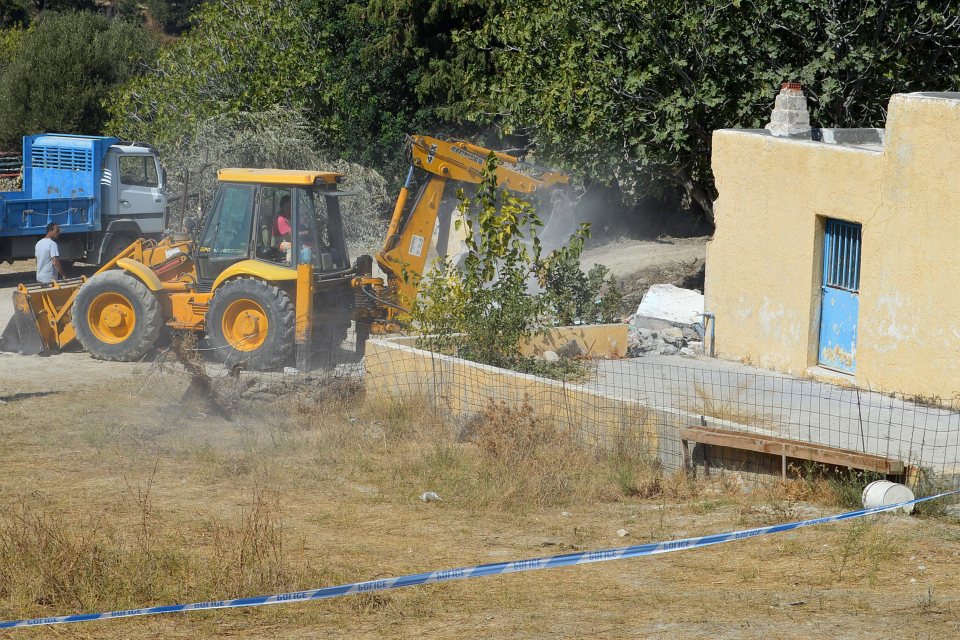  A bulldozer demolishes the lower part of the farmhouse near where British toddler Ben Needham disappeared