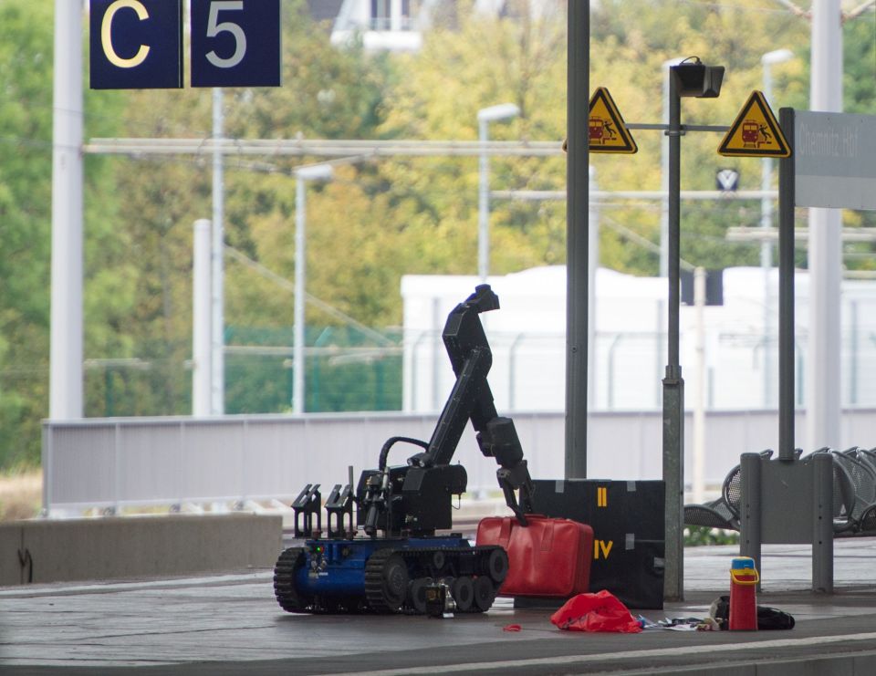  A remote controlled robot examines the luggage of two people arrested at the city's train station