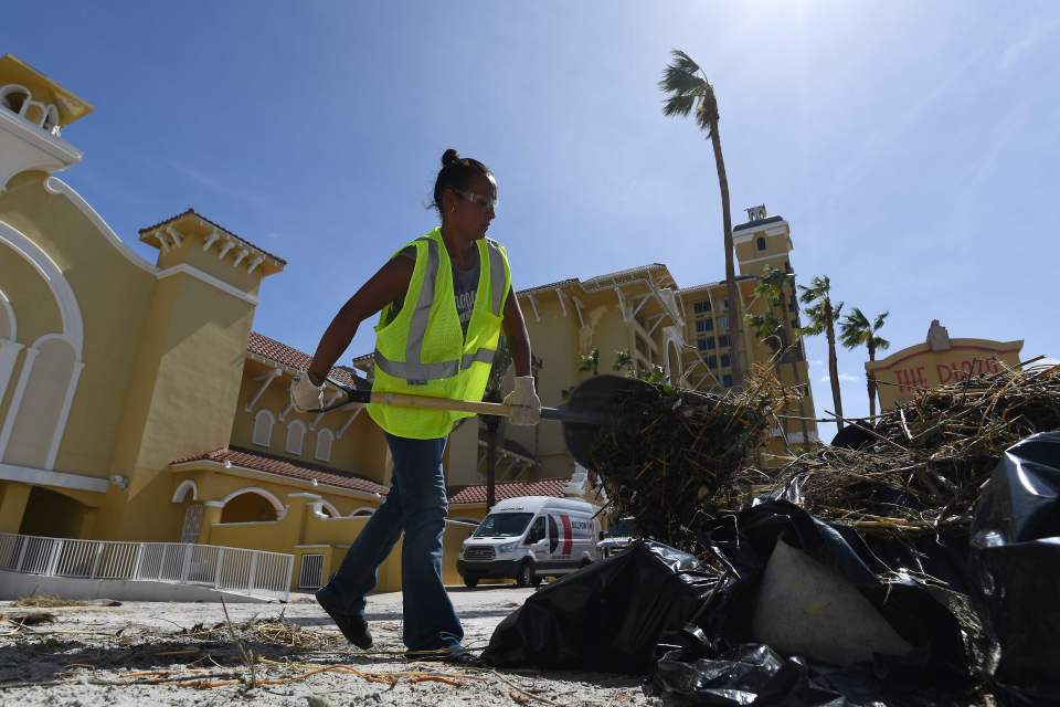  A worker cleans debris in Daytona Beach, Florida, after Hurricane Matthew hit the east coast of the US