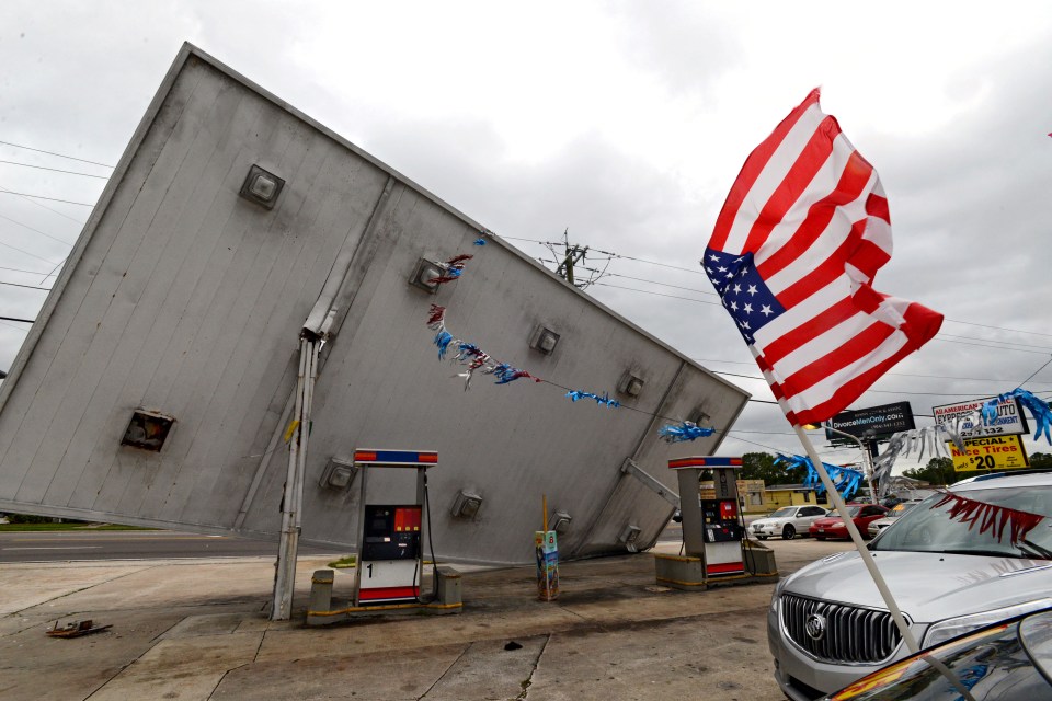  An American flag flutters in the wind near the roof over the gas pumps at the SG Food Store damaged by Hurricane Matthew in Jacksonville, Florida