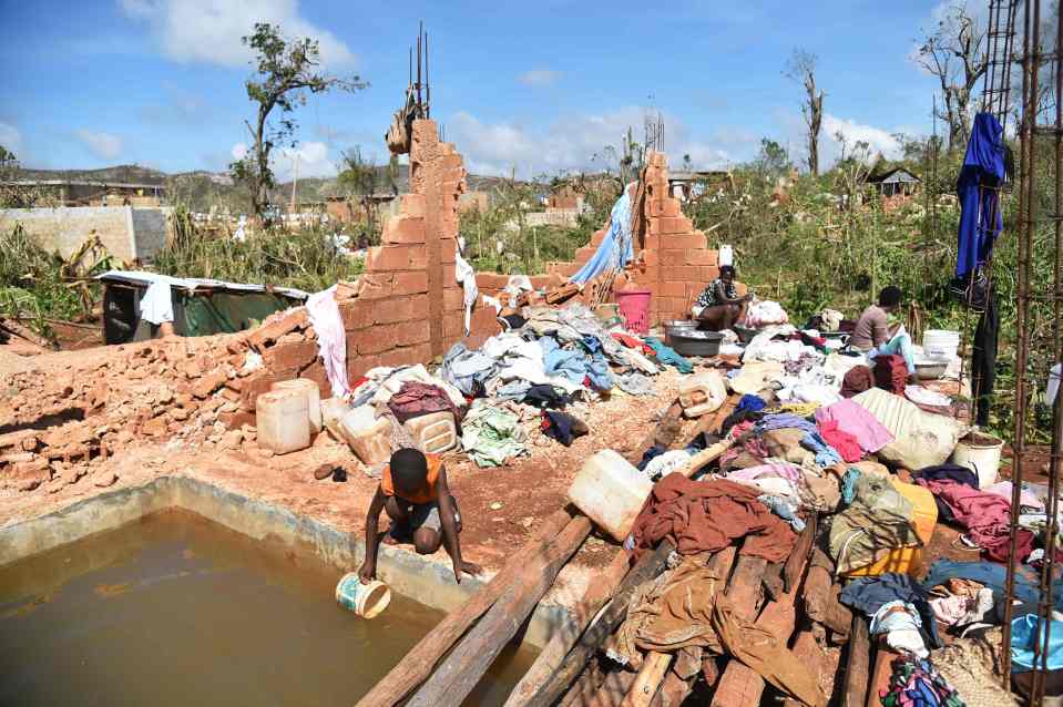  A child collects water with a bucket in a home destroyed by Hurricane Matthew, in the small village of Casanette, Haiti