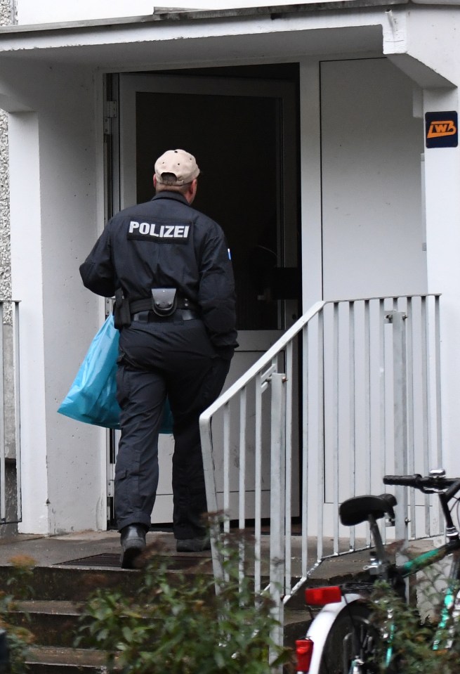  A police officer stands in front of another apartment in the Paunsdorf district of Leipzig on October 10