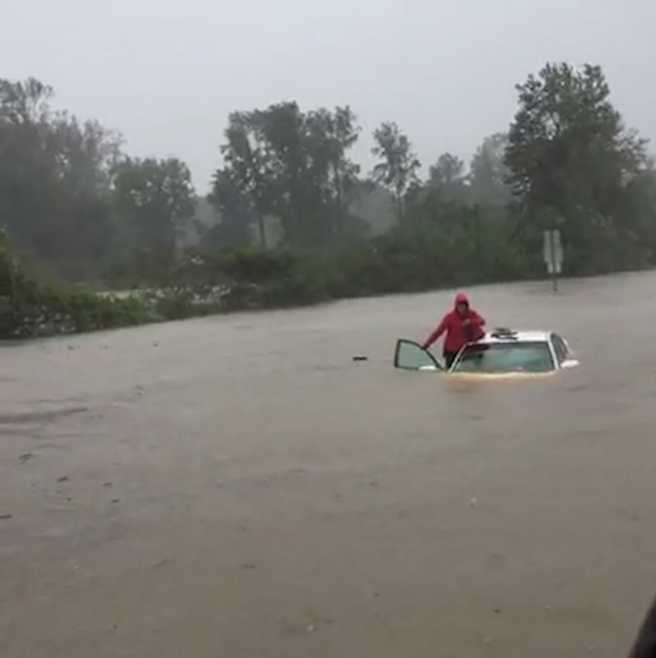 Cops spotted a woman holding her child stranded on their white vehicle in floodwater