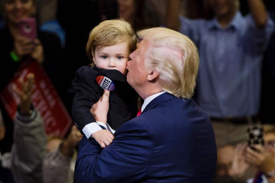  The billionaire gives the toddler a kiss on the cheek much to the delight of his supporters